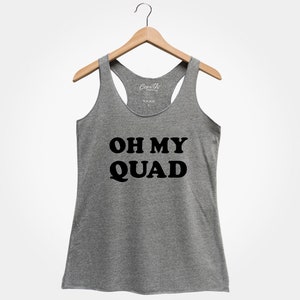 May include: A grey racerback vest with the words "OH MY QUAD" printed in bold black letters. The vest is displayed on a wooden hanger against a white backdrop. The top is sleeveless.