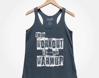 Może przedstawiać: Granatowy top na ramiączkach z białym nadrukiem "YOUR WORKOUT IS MY WARMUP".