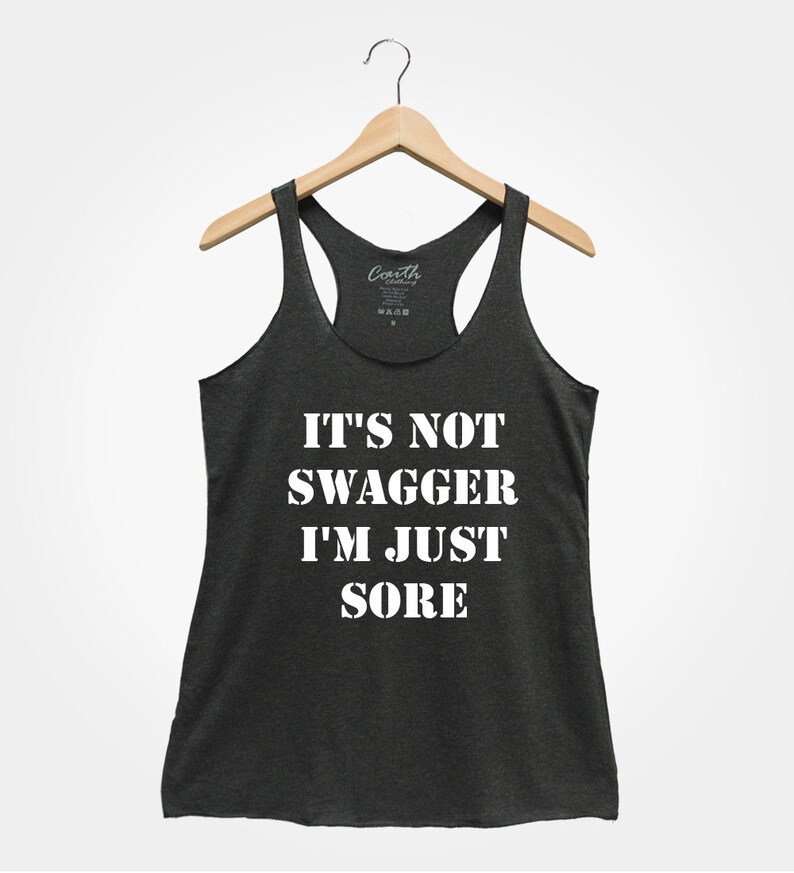 K&ouml;nnte beinhalten: Ein dunkelgraues Tanktop mit dem Text "IT'S NOT SWAGGER I'M JUST SORE" in wei&szlig; gedruckt.