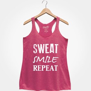 May include: Pink tank top with the text "SWEAT SMILE REPEAT" in white.