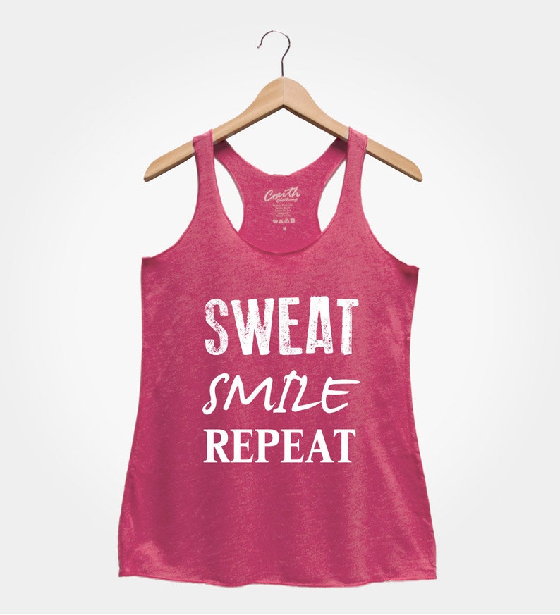 May include: Pink tank top with the text "SWEAT SMILE REPEAT" in white.