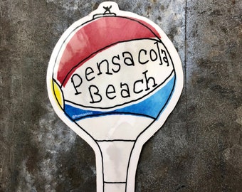 May include: A white, red, blue, and yellow beach ball sticker with the text "Pensacola Beach" in black. The sticker is shaped like a hot air balloon.
