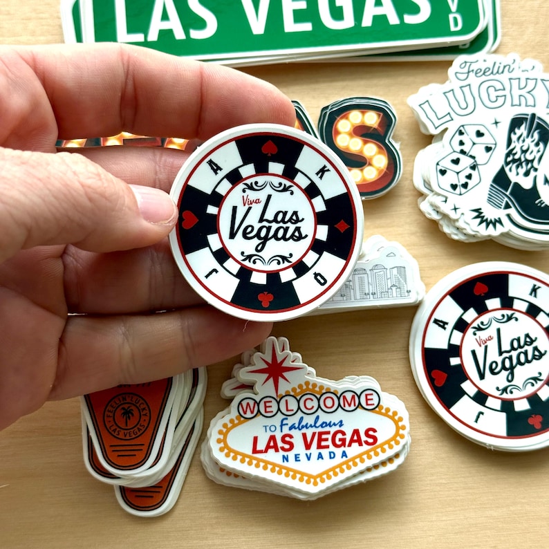 May include: A collection of Las Vegas-themed stickers. One sticker is a casino chip design with the words "Viva Las Vegas". Other stickers include a "Welcome to Fabulous Las Vegas Nevada" sign, dice, and a cowboy boot.