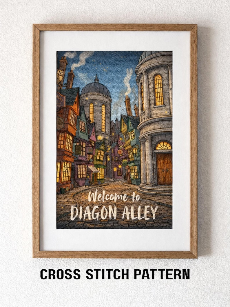 Op de afbeelding: Een ingelijst kruissteekpatroon met een gedetailleerde illustratie van Diagon Alley. Het kunstwerk toont kleurrijke gebouwen, geplaveide straten en de tekst "Welcome to Diagon Alley". De lijst is van hout.