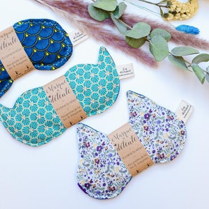 May include: Three eye masks with different patterns. The masks are made of fabric and have a brown label that says "Le Masque de détente" and "It's time to relax.  Aux grains de lin & de lavande."