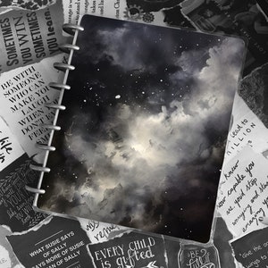 Puede incluir: Un cuaderno negro y blanco con un diseño de temática galáctica. El cuaderno tiene una encuadernación en espiral plateada y está rodeado de citas y refranes inspiradores. Las citas incluyen "Cada niño es talentoso" y "Sé lleno de alegría".