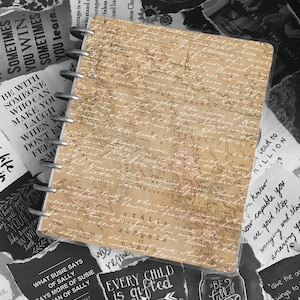 May include: A black and white image of a brown leather bound journal with a vintage map design. The journal is open and has a ring binder. The image also includes several black and white paper scraps with inspirational quotes, such as "Every child is gifted" and "Be full of joy".