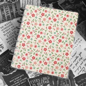 May include: A white and pink floral patterned notebook cover with a black and white quote that reads "Every child is gifted. They just unwrap their packages at different times."