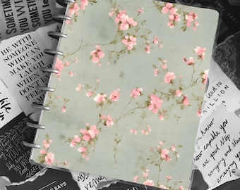 May include: A floral patterned notebook with a ring binder. The notebook is open and the pages are blank. The notebook is surrounded by pieces of paper with inspirational quotes. The quotes include "Every child is gifted" and "Be full of joy".