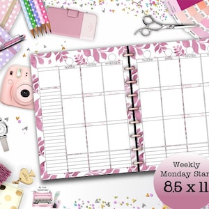 Puede incluir: Un planificador semanal con inicio el lunes, con un diseño floral rosa. El planificador mide 21,6 x 27,9 cm y tiene una encuadernación en espiral. Otros artículos incluyen una cámara rosa, bolígrafos y un reloj.