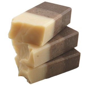 May include: A stack of three handmade soap bars with a brown, beige, and white layered design. The soap bars are made with natural ingredients and are perfect for sensitive skin.