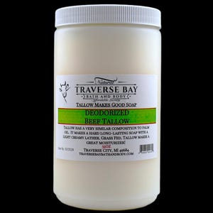 May include: A white plastic jar containing 32 ounces of deodorized beef tallow. The label features a cow illustration, the text Natural Traverse Bay Bath and Body, Tallow Makes Good Soap, Deodorized Beef Tallow, and usage information.