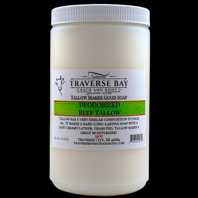 May include: A white plastic jar containing 32 ounces of deodorized beef tallow. The label features a cow illustration, the text Natural Traverse Bay Bath and Body, Tallow Makes Good Soap, Deodorized Beef Tallow, and usage information.