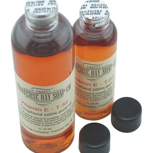 May include: Two amber glass bottles with black caps, labeled "Traverse Bay Soap Co. Natural Affordable Luxury Vitamin E - T-50 Tocopherol 100% pure oil 4 oz wt"