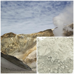 May include: A close-up of a pile of light gray volcanic ash. The ash is loose and powdery, with a slightly rough texture. The ash is a byproduct of volcanic activity and is often used in gardening and landscaping.