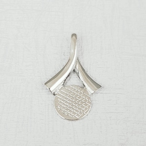 May include: Silver pendant with a circular design and a textured surface. The pendant has a loop at the top for attaching to a chain.