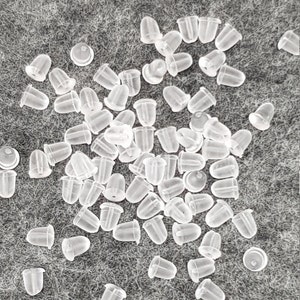Peut inclure: Un grand tas de dos d'oreille en plastique transparent. Les dos sont petits et ronds avec une pointe.