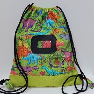 Snacktasche, Schwimmbadtasche, Kinderrucksack aus Dinosaurierstoff auf grünem Hintergrund