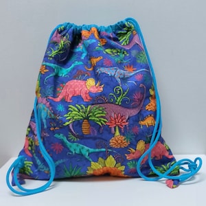 Kinderrucksack, Snacktasche, Schwimmbadtasche aus Dinosaurierstoff auf blauem Hintergrund