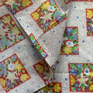 May include: White fabric with a repeating pattern of red, yellow, blue, and green floral squares. The fabric has a subtle dotted texture.