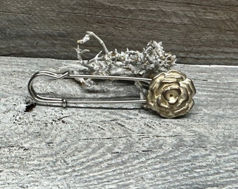 Poncho pin brooch made of metal in gold silver. The shape is a rose. Can be used as a kilt pin, safety pin, cloth clasp, poncho pin