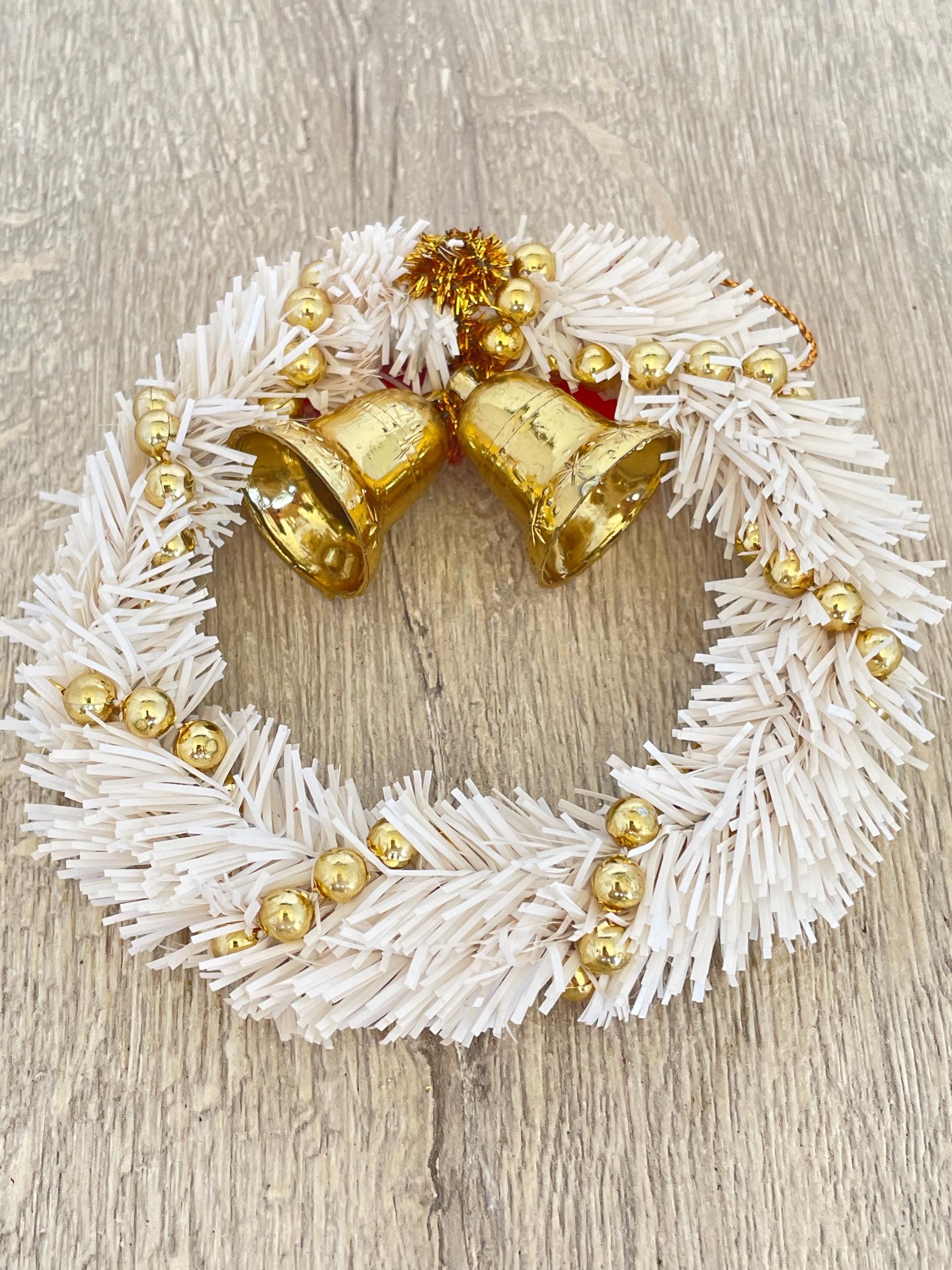 金色のベルと赤いリボンが付いた白いミニティンセルクリスマスリース