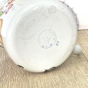 May include: White enamelware jug with a floral design and a circular stamp that reads "USSR Made".