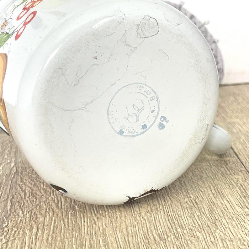May include: White enamelware jug with a floral design and a circular stamp that reads "USSR Made".