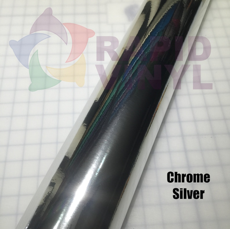 May include: A roll of chrome silver vinyl with a reflective surface. The vinyl is on a white background with a grid pattern.