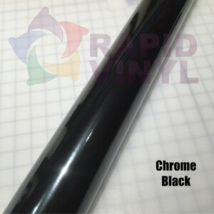 May include: A roll of chrome black vinyl wrap. The vinyl is shiny and reflective. The text "RAPID VINYL" is visible on the roll.