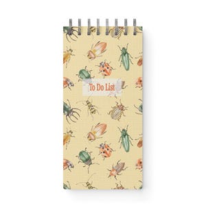 May include: A spiral-bound notepad with a cream-colored background, covered in watercolor illustrations of various insects. The insects are in shades of green, orange, yellow, and brown. The words "To Do List" are printed on a white label.