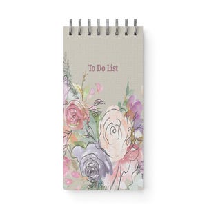 May include: A spiral-bound notepad with a beige cover featuring the text "To Do List" in a soft purple hue. The notepad is adorned with a watercolor floral design in shades of pink, purple, and green.