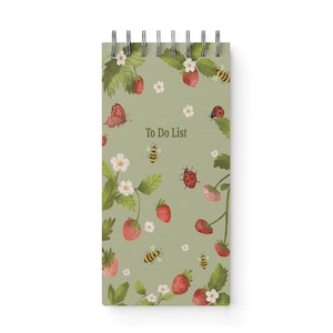 May include: A spiral-bound notepad with a light green background, adorned with illustrations of strawberries, bees, ladybugs, butterflies, and flowers. The words "To Do List" are printed in the center.