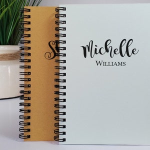 Personalized handmade notebooks with the names centered on the cover. The custom handmade notebooks are available in the colors kraft, white, rose (dusky pink), honeycomb (yellow), powder green and light blue.