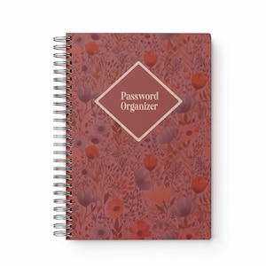 May include: A floral-patterned password organizer with a spiral binding. The cover is a mix of red, orange, and purple hues, with a diamond-shaped label that reads "Password Organizer".
