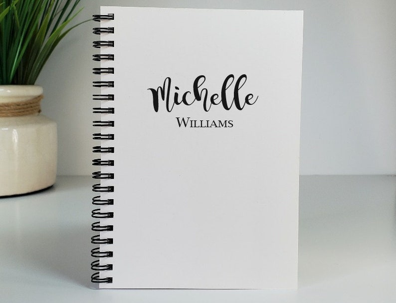 Personalized handmade notebook with the name centered on the cover. The notebook shown is with white covers. These custom notebooks are great for girls or boys, and women. Perfect gift idea for party favors, students and teachers.