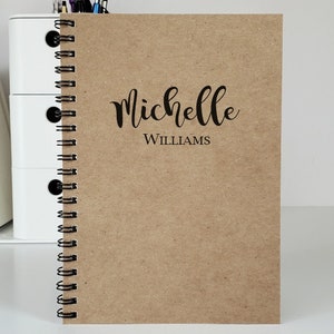 Personalized notebook with the name centered on the cover. The notebook shown is with kraft covers. These custom notebooks are great for girls or boys, and women. Perfect gift idea for party favors, students and teachers.