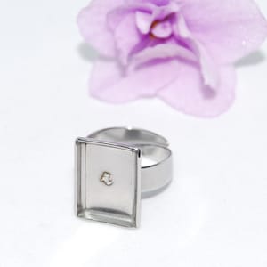 Peut inclure: Une bague en argent avec un sertissage carré. Le sertissage est vide et prêt à être rempli d'une pierre ou d'un autre ornement.