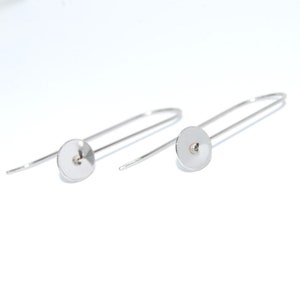 Peut inclure: Une paire de supports de boucles d'oreilles en argent avec un disque rond et plat à l'extrémité de chaque fil.