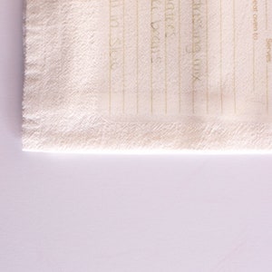 May include: A white kitchen towel with a blank recipe template printed on it. The template has lines for ingredients and instructions, as well as spaces for the name of the recipe, the oven temperature, and the number of servings.