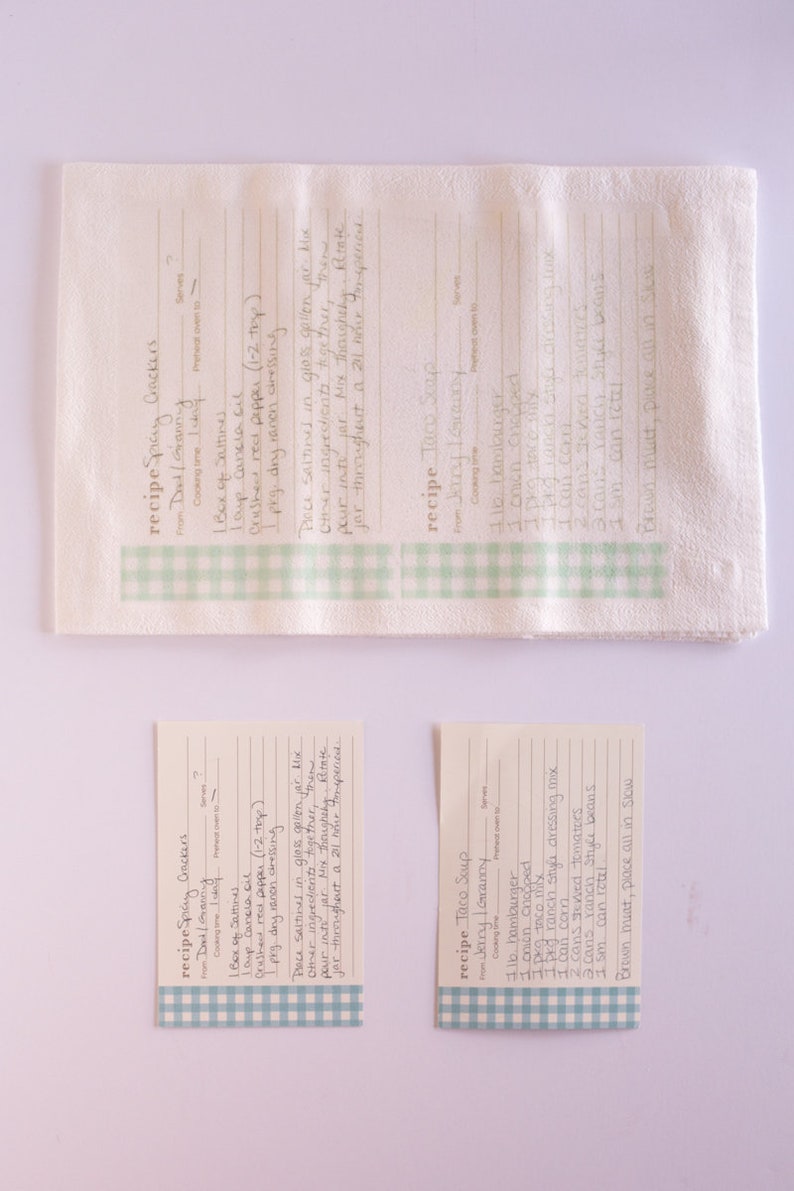 May include: Three recipe cards with a green and white checkered border. The cards are for Spicy Crackers, Taco Soup, and Spicy Crackers. The recipe cards are written in cursive handwriting.