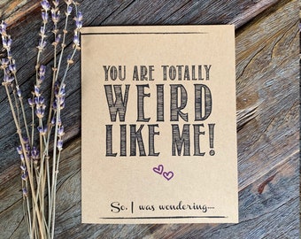 May include: A brown card with the text "You are totally weird like me!" in black lettering. The card has two small purple hearts and the text "So, I was wondering..." in black lettering.