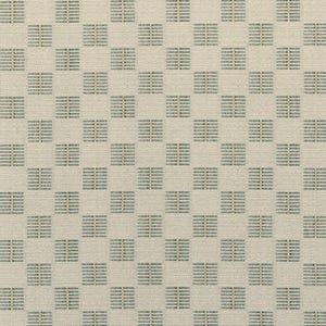 May include: A woven fabric featuring a repeating grid pattern of light beige squares interspersed with smaller, darker teal and tan rectangular blocks. The textile has a visible, textured weave throughout, creating a structured and uniform appearance.