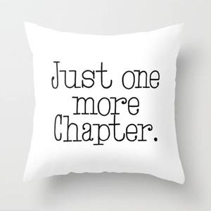 Op de afbeelding: Een wit kussen met zwarte tekst die "Just one more chapter." luidt.