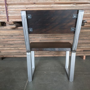 May include: A wooden chair with a dark brown stained seat and back. The chair has a metal frame with a silver finish.