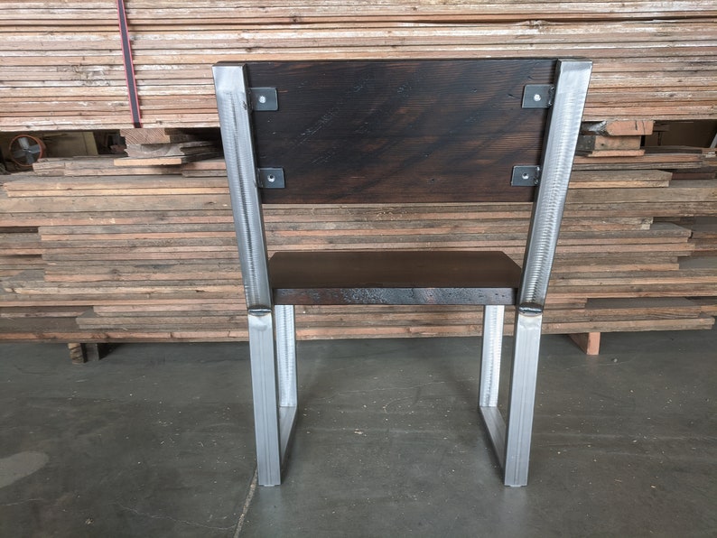 May include: A wooden chair with a dark brown stained seat and back. The chair has a metal frame with a silver finish.