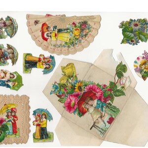 Op de afbeelding: Een vintage papieren knutselset met kinderen met paraplu's en bloemmotieven. De set bevat een waaierkaart, een doos met een bloemmotief en verschillende individuele uitsnijdingen.
