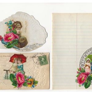 Op de afbeelding: Een vintage ansichtkaart met een rode paraplu en twee kinderen eronder. De ansichtkaart heeft een bloemmotief met roze en gele bloemen. De ansichtkaart heeft een postzegel van 10 mei 1917.