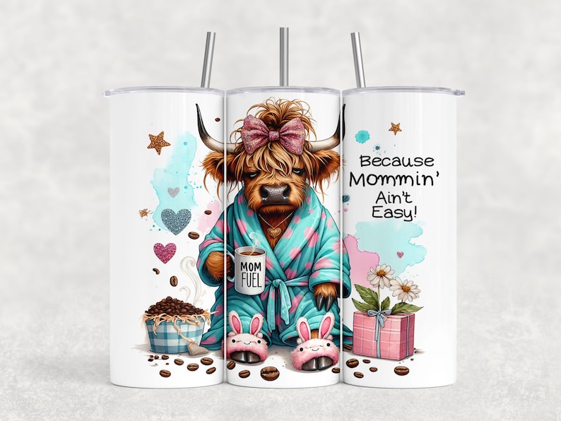 A funny Highland cow in a polka-dot robe, pink bunny slippers, and coquette bow holding a "Mom Fuel" mug, surrounded by coffee beans, glitter hearts, daisies, and a pink gift box. Text reads, "Because Mommin’ Ain’t Easy!" on a playful background.