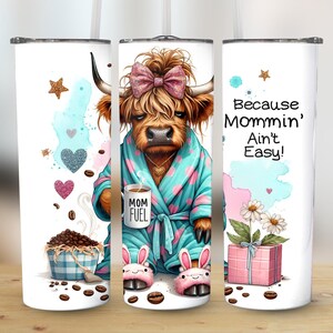 A funny Highland cow in a polka-dot robe, pink bunny slippers, and coquette bow holding a "Mom Fuel" mug, surrounded by coffee beans, glitter hearts, daisies, and a pink gift box. Text reads, "Because Mommin’ Ain’t Easy!" on a playful background.